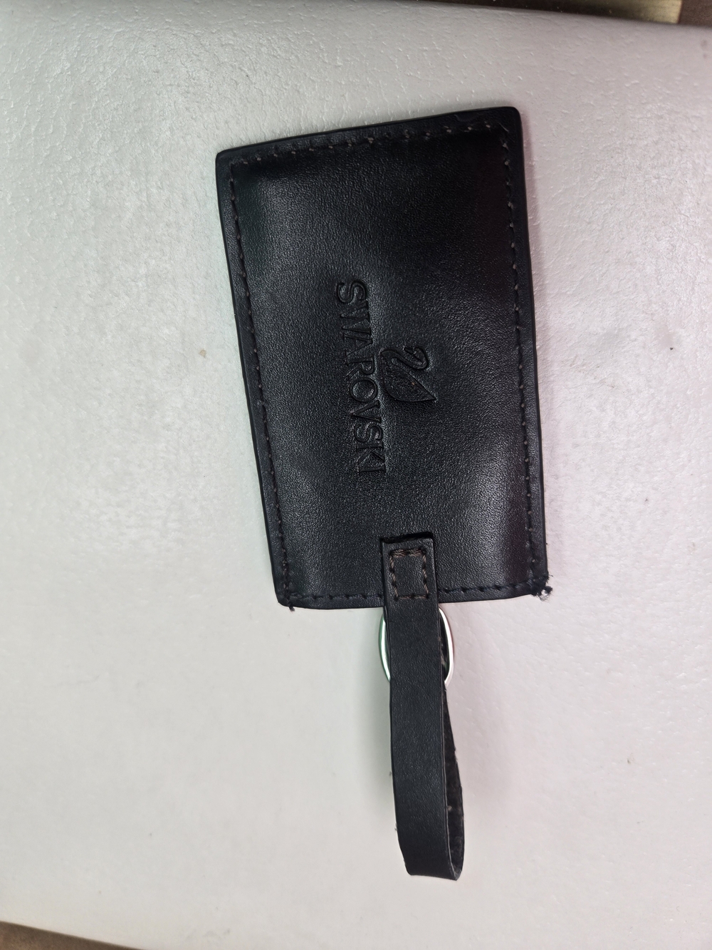 black Swarovski leather luggage tag featuring an embossed logo